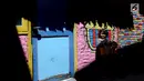 Dua anak sedang berpose dengan latar belakang gambar klub sepak bola Barcelona di kampung warna-warni Kelurahan Kesatrian, Kota Malang, Minggu (5/11). Pengecatan rumah dilakukan agar tidak terkesan kumuh. (Liputan6.com/Fery Pradolo)