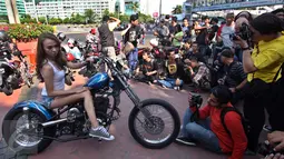 Seorang model berpose di atas motor gede di Jalan MH Thamrin, Jakarta, Minggu (19/7/2015). Momen Jakarta sepi akibat banyak yang mudik, dimanfaatkan fotografer untuk memotret model. (Liputan6.com/Johan Tallo)