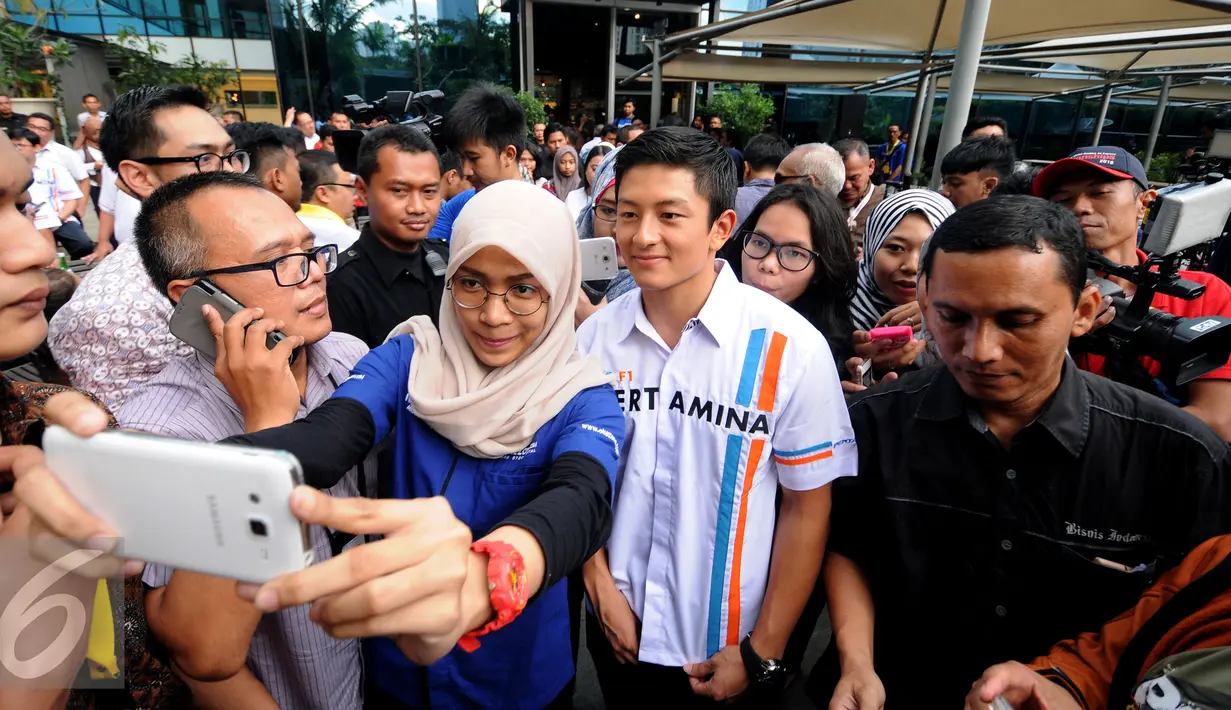 Rio Haryanto berselfie bersama penggemarnya jelang Meet and Great di Mall Kota Kasablanka, Jakarta, Kamis (7/4/2016). Rio, pembalap Indonesia pertama yang turun di ajang balap Formula 1. (Liputan6.com/Helmi Fithriansyah)