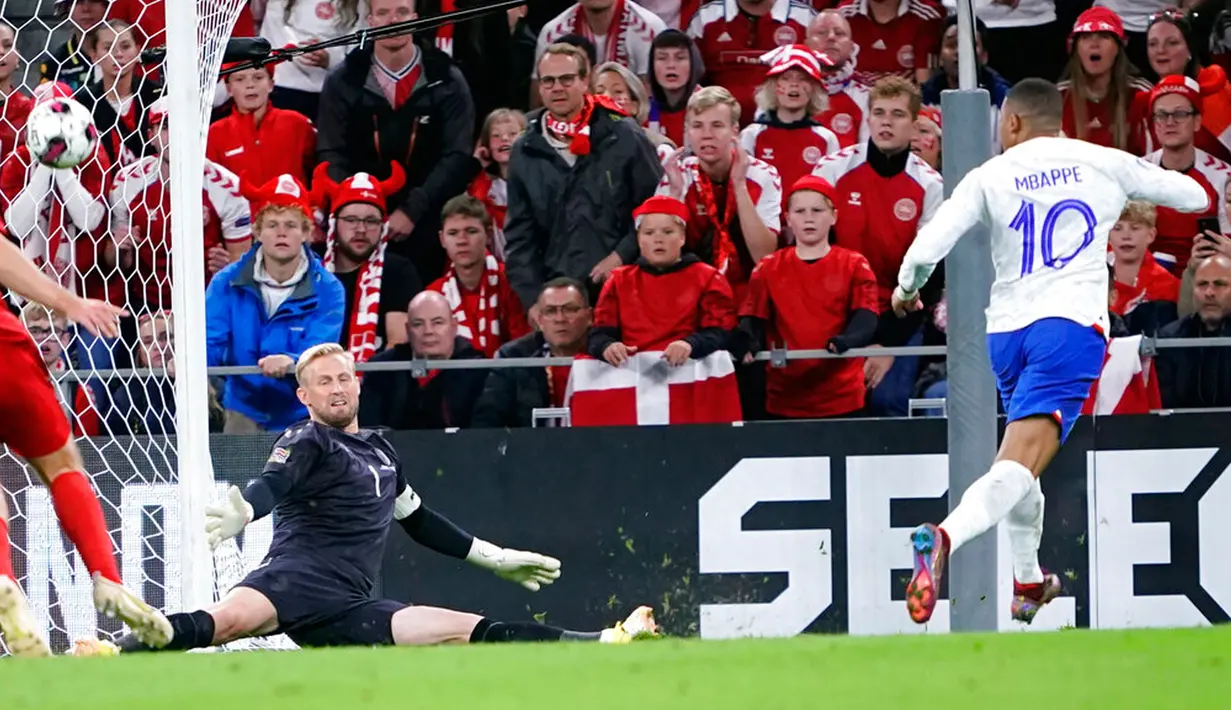 Penjaga gawang Denmark Kasper Schmeichel melakukan penyelamatan dari pemain Prancis Kylian Mbappé (kanan) pada pertandingan sepak bola UEFA Nations League di Parken Stadium, Kopenhagen, Denmark, 25 September 2022. Denmark mengalahkan Prancis dengan skor 2-0. (Liselotte Sabroe/Ritzau Scanpix via AP)