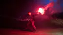 Seorang penari memegang suar selama pertunjukan 'RUSH', pertunjukan tari, cahaya, musik dan proyeksi dalam Festival Seni Visual Lightpool di situs bekas kantor polisi, Blackpool, Inggris (26/10). (AFP Photo/Oli Scarff)
