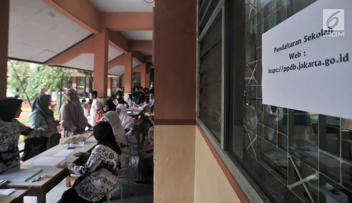 Sejumlah calon siswa baru didampingi orangtuannya menunggu antrean pengambilan nomor token PPDB di SMPN 92, Jakarta, Senin (25/6). Saat pengambalilan nomor token harus disertai Kartu Keluarga, ijazah, dan identitas lainnya. (Merdeka.com/Iqbal S Nugroho)