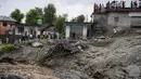 Orang-orang menyaksikan kerusakan yang disebabkan oleh tanah longsor setelah hujan deras di Khaniyara, dekat Dharmsala, India (2/9/2022). Tidak ada korban jiwa yang dilaporkan akibat musibah tersebut. (AP Photo/Ashwini Bhatia)