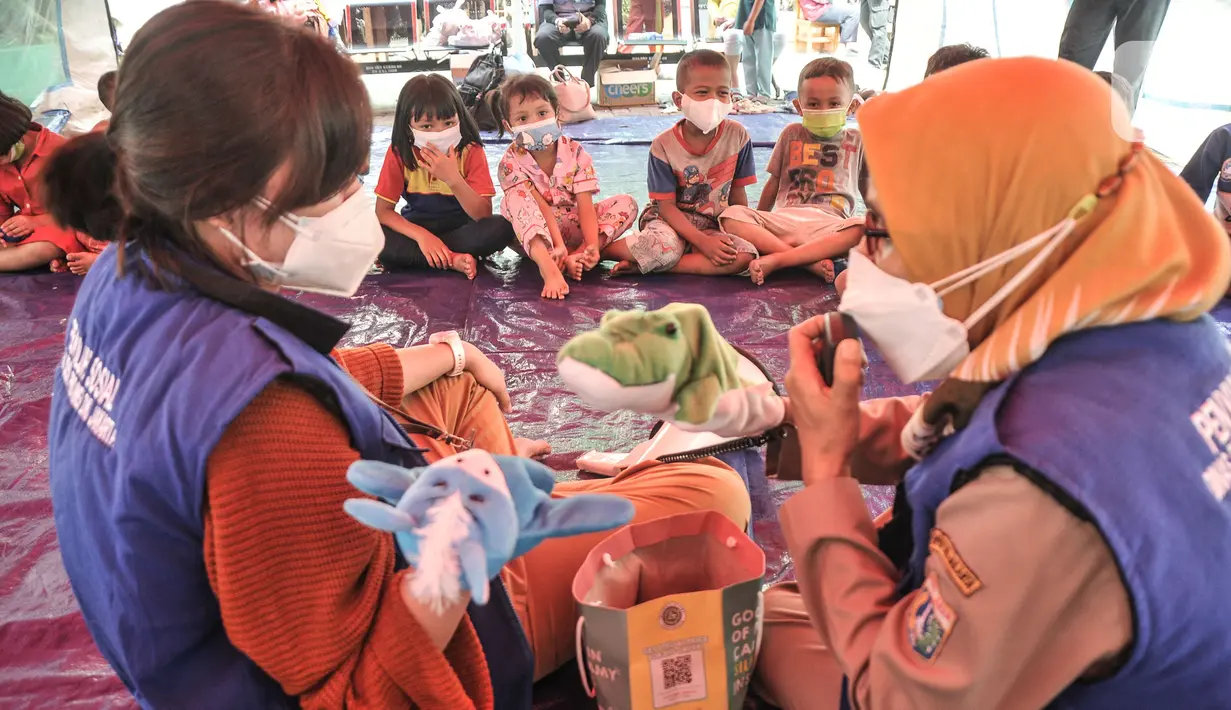 Petugas dari Dinas Sosial DKI Jakarta mengisahkan dongeng dengan boneka saat program trauma healing kepada anak-anak korban kebakaran yang mengungsi di SDN 09 Kebon Kosong, Kemayoran, Jakarta, Selasa (31/8/2021). (merdeka.com/Iqbal S. Nugroho)