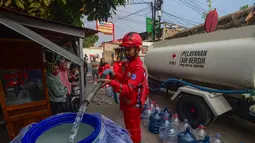 Petugas Palang Merah Indonesia (PMI) mengisi air bersih ke dalam toren air milik warga di RW 08. Cipayung Jaya, Kota Depok, Jawa Barat, Jumat (14/07/2026).