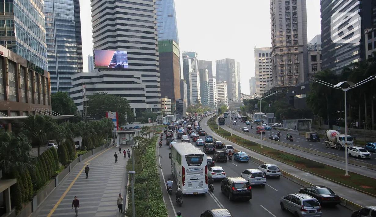 Kendaraan bermotor melintas di antara gedung bertingkat di kawasan Sudirman, Jakarta, Jumat (15/11/2019). Gubernur DKI, Anies Baswedan, memastikan, meski ibu kota akan pindah ke  Kalimantan Timur, Jakarta akan tetap menjadi pusat perekonomian Indonesia. (Liputan6.com/Angga Yuniar)