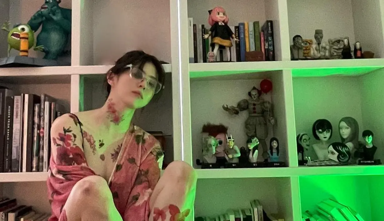 Ia memadukan tanktop dan celana pendek hitam guna memperlihatkan tato bunga di lengan dan kakinya [@xeesoxee]