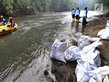 Sukarelawan mengarungi sungai dengan perahu karet saat kegiatan Bebersih Ciliwung di Yayasan Bambu Indonesia, Cibinong, Bogor, Jawa Barat, Minggu (23/6/2019). Kegiatan gotong royong ini digelar oleh Kementerian Lingkungan Hidup dan Kehutanan (KLHK). (merdeka.com/Arie Basuki)
