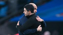 Pelatih Manchester City, Pep Guardiola memeluk pelatih Arsenal, Mikel Arteta, setelah laga final Carabao Cup di Stadion Wembley, Minggu (22/3/2026). (AFP/Glyn Kirk)