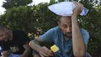 Michael Williams mendinginkan diri dengan es loli dan sekantong es saat suhu di Santa Rosa, California, naik 112 derajat, Senin, 5 September 2022. Barang-barang tersebut disumbangkan oleh sekelompok anggota komunitas di Santa Rosa. (Kent Porter/The Press Democrat via AP)