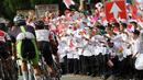 Anak-anak sekolah mengibarkan bendera Merah-Putih saat balapan Tour de Singkarak 2016, di Sumatera Barat, (12/8/2016). (Bola.com/Nicklas Hanoatubun)