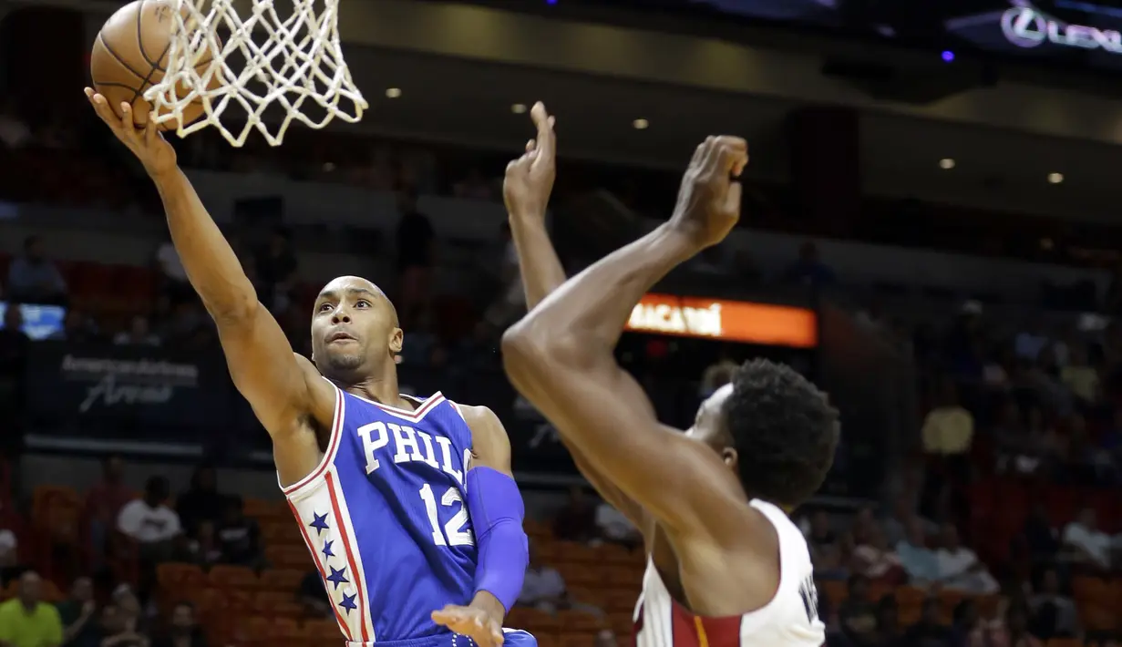 Philadelphia 76ers guard Gerald Henderson #12 melakukan layup saat dibayangi pemain Miami Heat pada laga NBA preseason basketball game di Miami, Sabtu (22/10/2016) WIB. (AP/Alan Diaz)