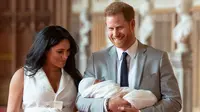 Pangeran Harry dan Meghan Markle berjalan membawa bayi laki-lakinya yang baru lahir di St George's Hall di Windsor Castle di Windsor, London (8/5/2019). Pangeran Harry menyatakan bahwa dia dan Meghan Markle masih memikirkan nama anak mereka. (AFP Photo/Dominic Lipinski)