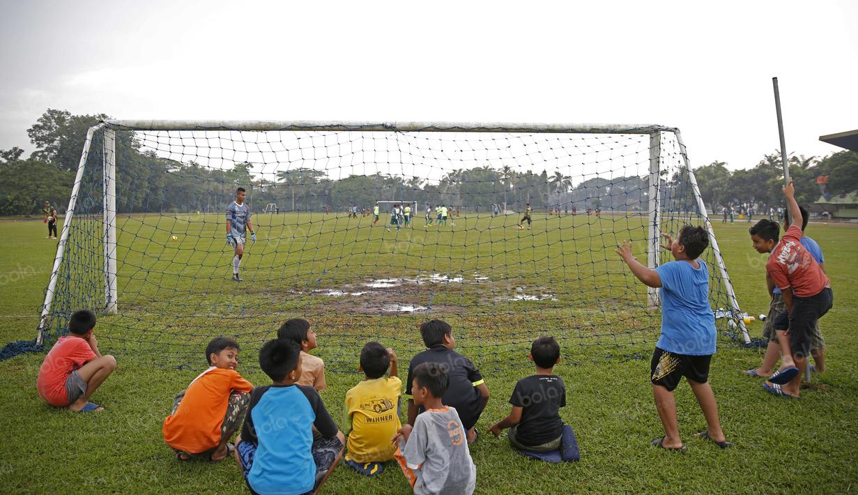 Anak-anak sedang menikmati tontonan laga uji coba PS TNI di Lapangan Mako Kostrad, Cilodong, Depok, Rabu (13/4/2016). (Bola.com/Nicklas Hanoatubun)
