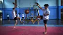 Dua siswa menggunakan pedang berlatih Krabi Krabong di sekolah Thonburee Woratapeepalarak, Thonburi, Bangkok (8/7/2019). Krabi Krabong merupakan seni bela diri Thailand yang dipersenjatai pisau dan perisai kayu yang terabaikan. (AFP Photo/Lillian Suwanrumpha)