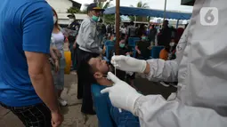 Seorang pria menjalani tes usap atau Swab Antigen di Pelabuhan Kali Adem, Jakarta, Kamis (31/12/2020). Pemeriksaan swab antigen kepada wisatawan yang akan liburan Tahun Baru di Kepulauan Seribu dilakukan untuk mencegah penyebaran COVID-19. (merdeka.com/Imam Buhori)