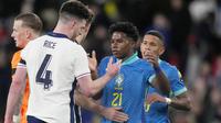 Pemain Brasil, Endrick, besalaman dengan pemain Inggris, Declan Rice, dalam laga persahabatan di Stadion Wembley, Minggu (24/3/2024). (AP Photo/Alastair Grant)