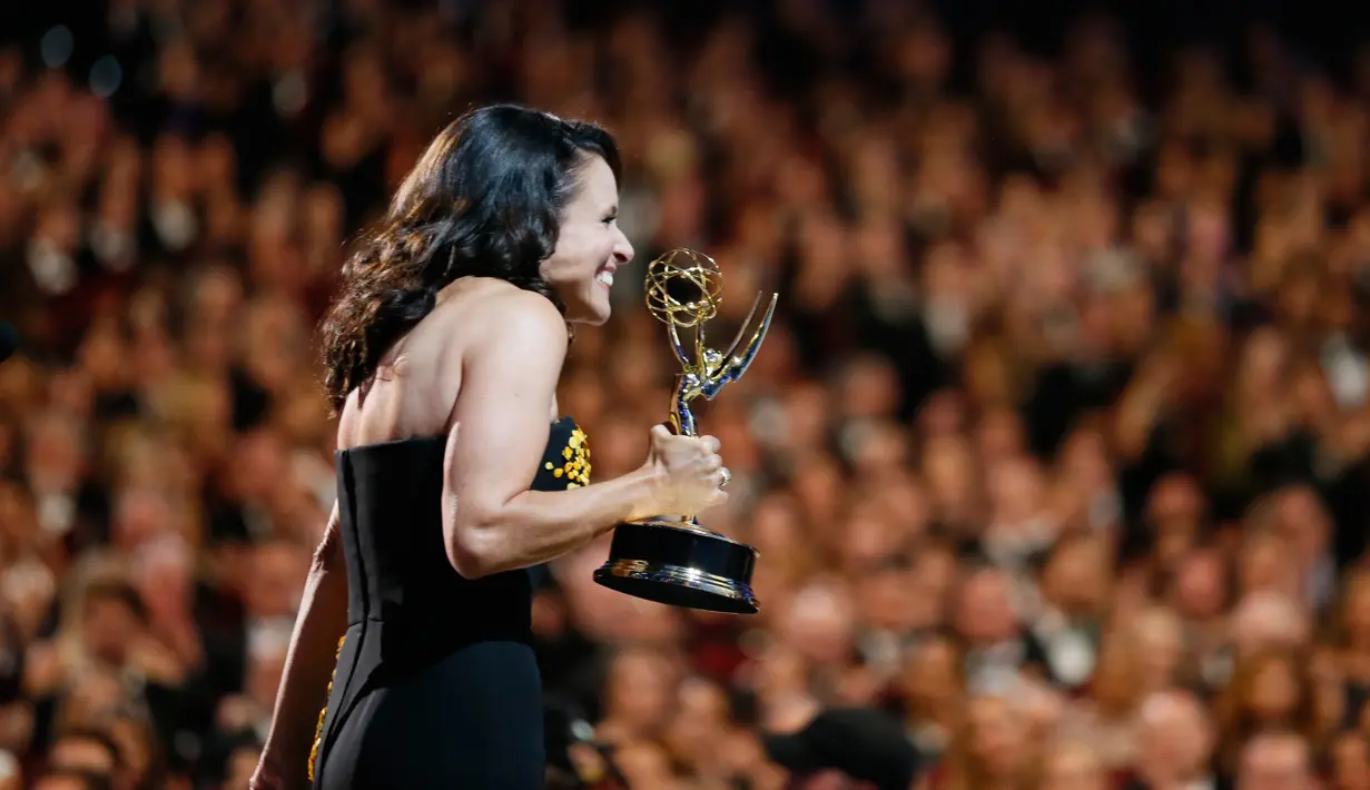 Aktris AS, Julia Louis-Dreyfus ketika menerima trofi di atas panggung Emmy Awards 2017 di Los Angeles, Minggu (17/9). Tahun ini Julia secara resmi memegang rekor sebagai pemenang Emmy terbanyak untuk satu akting. (Danny Moloshok/Invision/AP Images)