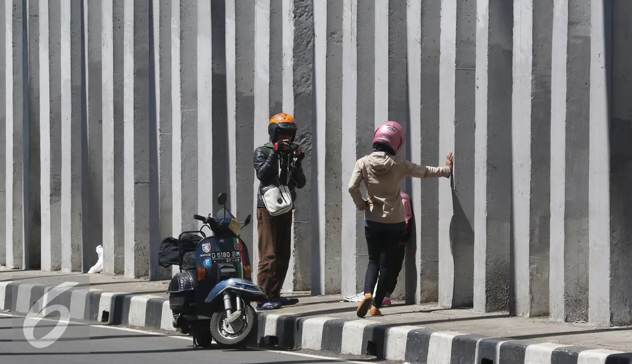 Pengendara berhenti untuk berfoto di terowongan lingkar luar Nagreg, Jawa Barat, Minggu (3/7).Para pengendara tetap berfoto meskipun terdapat larangan berhenti karena berbahaya bagi keselamatan. (Liputan6.com/Immanuel Antonius)