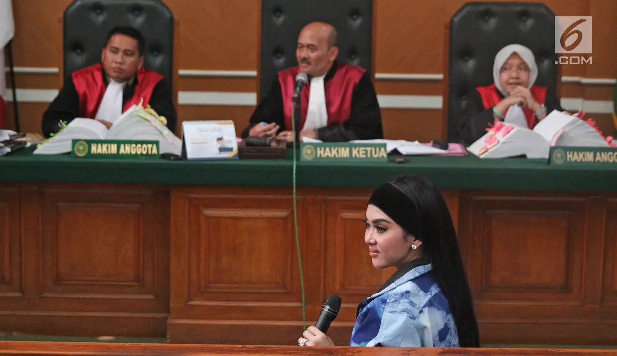 Penyanyi Syahrini menjadi saksi persidangan kasus First Travel di Pengadilan Negeri Depok, Jawa Barat, Senin (2/4). Saat memberikan kesaksian, Syahrini merasa kepanasan, sehingga kipas-kipas dan membuka jaket. (Liputan6.com/Herman Zakharia)