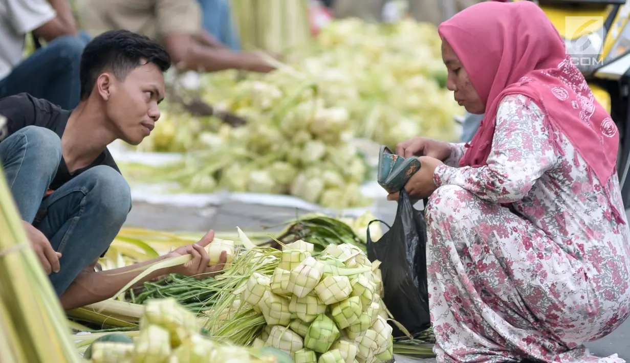 Pedagang melayani pembeli kulit ketupat untuk lebaran, Jakarta, Kamis (22/6). Menjelang Hari Raya Idul Fitri, pedagang kulit ketupat musiman mulai ramai di pasar tradisional. (Liputan6.com/Yoppy Renato)