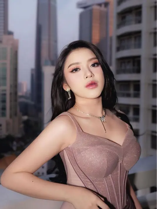 Dress rancangan @etiquette_white itu menampilkan detail shimmer pada bagian atasnya, sementara bagian rok hadir dengan model drapery yang menawan. [@rikkisi/@cielmakeupartist]