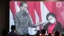 Ketua Umum PDIP Megawati Soekarnoputri (kanan) mengangkat tumpeng pemberian Presiden Joko Widodo atau Jokowi (kiri) saat Rakernas II PDIP di Jakarta, Selasa (21/6/2022). Rakernas PDIP kali ini mengusung tema 'Desa Kuat, Indonesia Maju dan Berdaulat'. (Liputan6.com/Faizal Fanani)