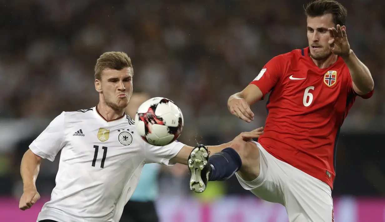 Aksi pemain Jerman, Timo Werner (kiri) dan pemain Norwegia, Harvard Nordtveit saat berebut bola pada laga grup C kualifikasi Piala Dunia 2018 di Mercedes-Benz Arena, Stuttgart, (4/9/2017). Jerman menang 6-0. (AP/Matthias Schrader)