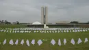 Pemandangan sapu tangan putih yang mewakili warga Brasil yang meninggal karena COVID-19 digantung oleh aktivis dari kelompok hak asasi manusia Rio de Paz, di depan Kongres Nasional di Brasilia, Senin (18/10/2021). Brasil pada 8 Oktober melampaui 600.000 kematian virus corona. (EVARISTO SA / AFP)