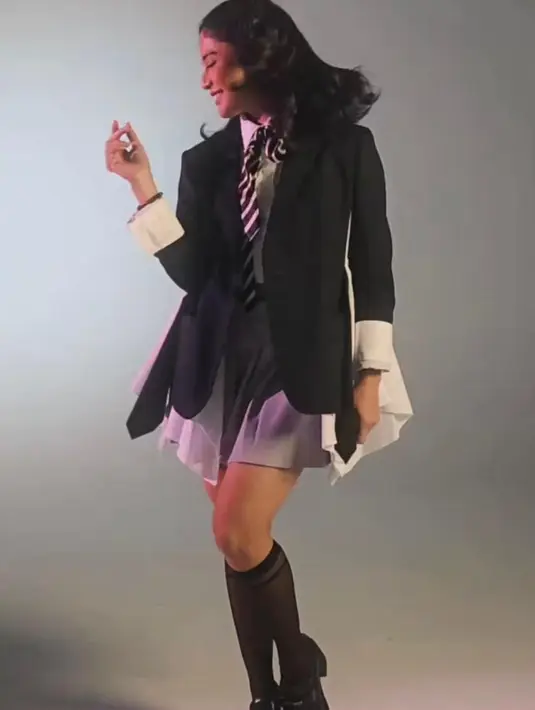 Dian mengenakan setelan blazer hitam berpotongan asimetris dengan detail layer putih yang memberi kesan edgy dan playful sekaligus.  [@therealdisastr].