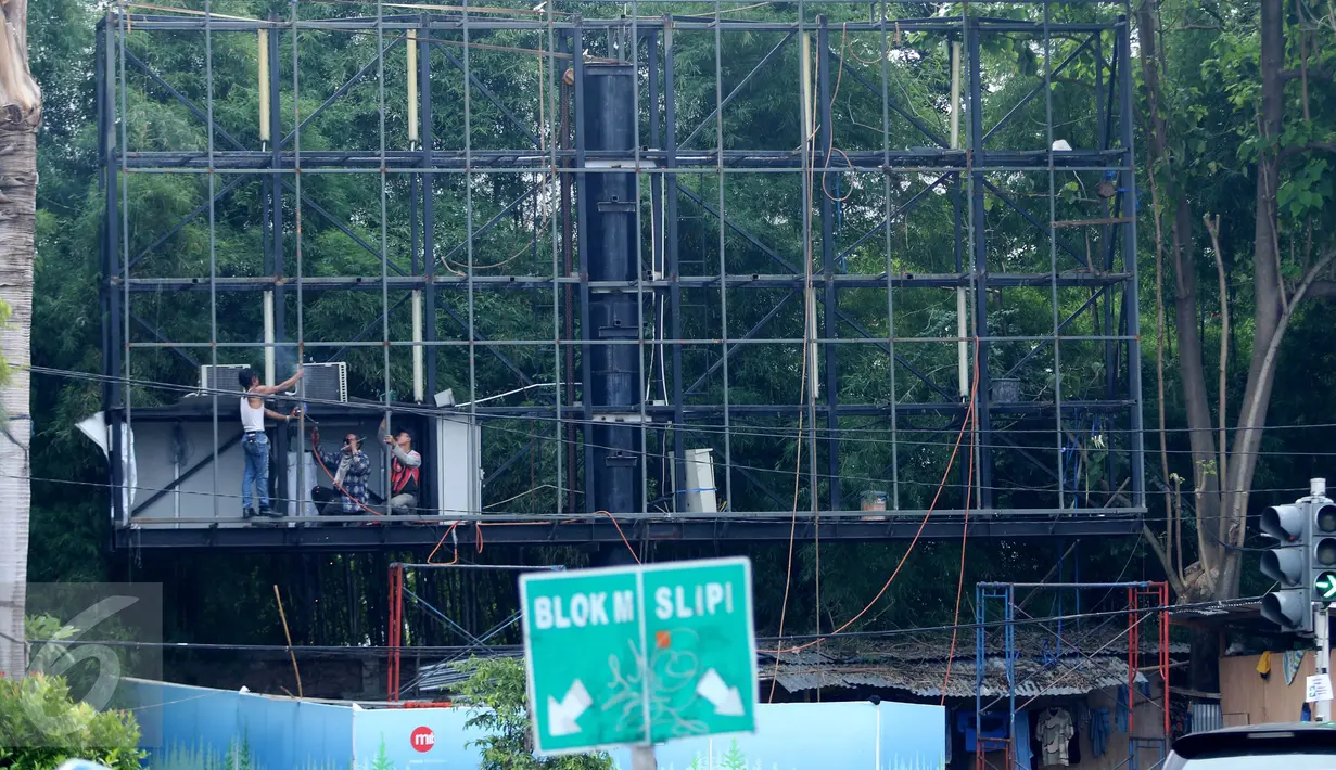 Pekerja memperbaiki papan reklame di Kawasan Senayan, Jakarta, Kamis, (6/10). Papan reklame diremajakan agar tidak roboh diterpa hujan deras disertai angin kencang. (Liputan6.com/Gempur M. Surya)