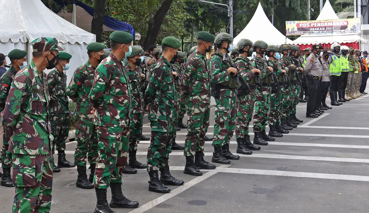 Sejumlah anggota gabungan melakukan pengamanan saat perayaan Paskah di Gereja Katedral, Jakarta, Jumat (2/4/2021). Pengamanan diperketat untuk mengatisipasi aksi teror menyusul adanya serangkaian teror dalam sepekan terakhir. (Liputan6.com/Herman Zakharia)