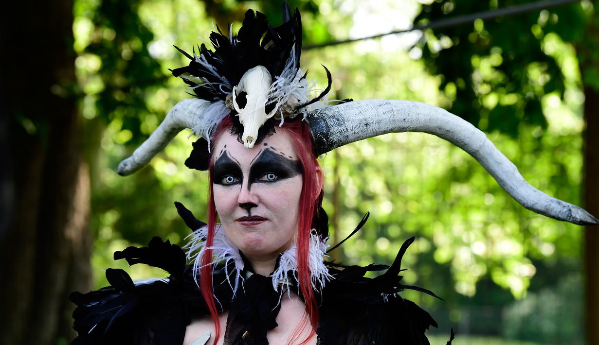 Seorang wanita berdandan serta mengenakan tanduk di kepalanya saat mengikuti Victorian Picnic selama festival Wave Gotik Treffen (WGT) di Leipzig, Jerman (6/2). (AFP Photo/Tobias Schwarz)