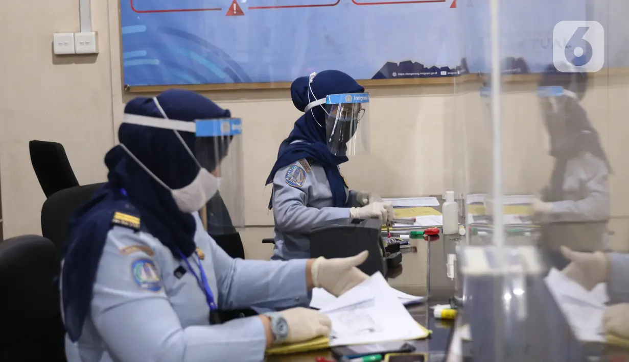 Pegawai dengan mengenakan masker dan pelindung wajah memproses pembuatan paspor di Kantor Imigrasi Kelas I Non TPI Tangerang, Senin (15/6/2020). Memasuki masa tatanan normal baru, pelayanan keimigrasian untuk warga mulai aktif kembali dengan menerapkan protokol kesehatan. (Liputan6.com/Angga Yuniar)