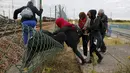 Sejumlah imigran gelap berusaha melewati pagar keamanan terminal Eurotunnel di Coquelles dekat Calais di Prancis, 29 Juli 2015. Ribuan imigran tersebut mencoba memasuki Terowongan Channel menuju Inggris melalui Prancis. (REUTERS/Pascal Rossignol)