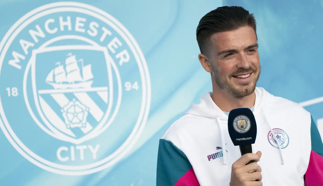 Pemain baru Manchester City Jack Grealish naik ke panggung saat diperkenalkan di Stadion Etihad, Senin (9/8/2021). Jack Grealish akan mengenakan kostum nomor 10, yang sebelumnya menjadi milik Sergio Aguero. (AP Photo/Jon Super)