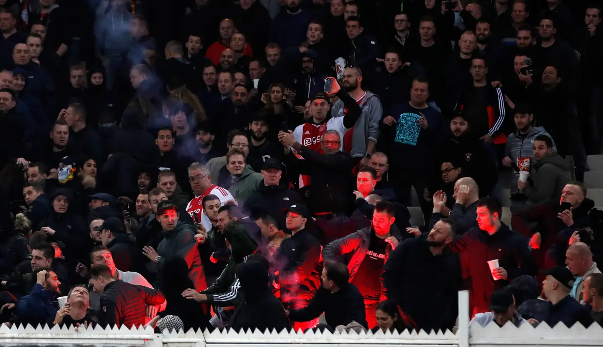 Flare dilemparkan ke arah suporter Ajax Amsterdam sebelum pertandingan Liga Champions melawan AEK Athena di Stadion Olimpiade Athena, Selasa (27/11). Suporter tuan rumah melempar flare dan bom molotov ke arah tribun suporter Ajax. (AP/Thanassis Stavrakis)