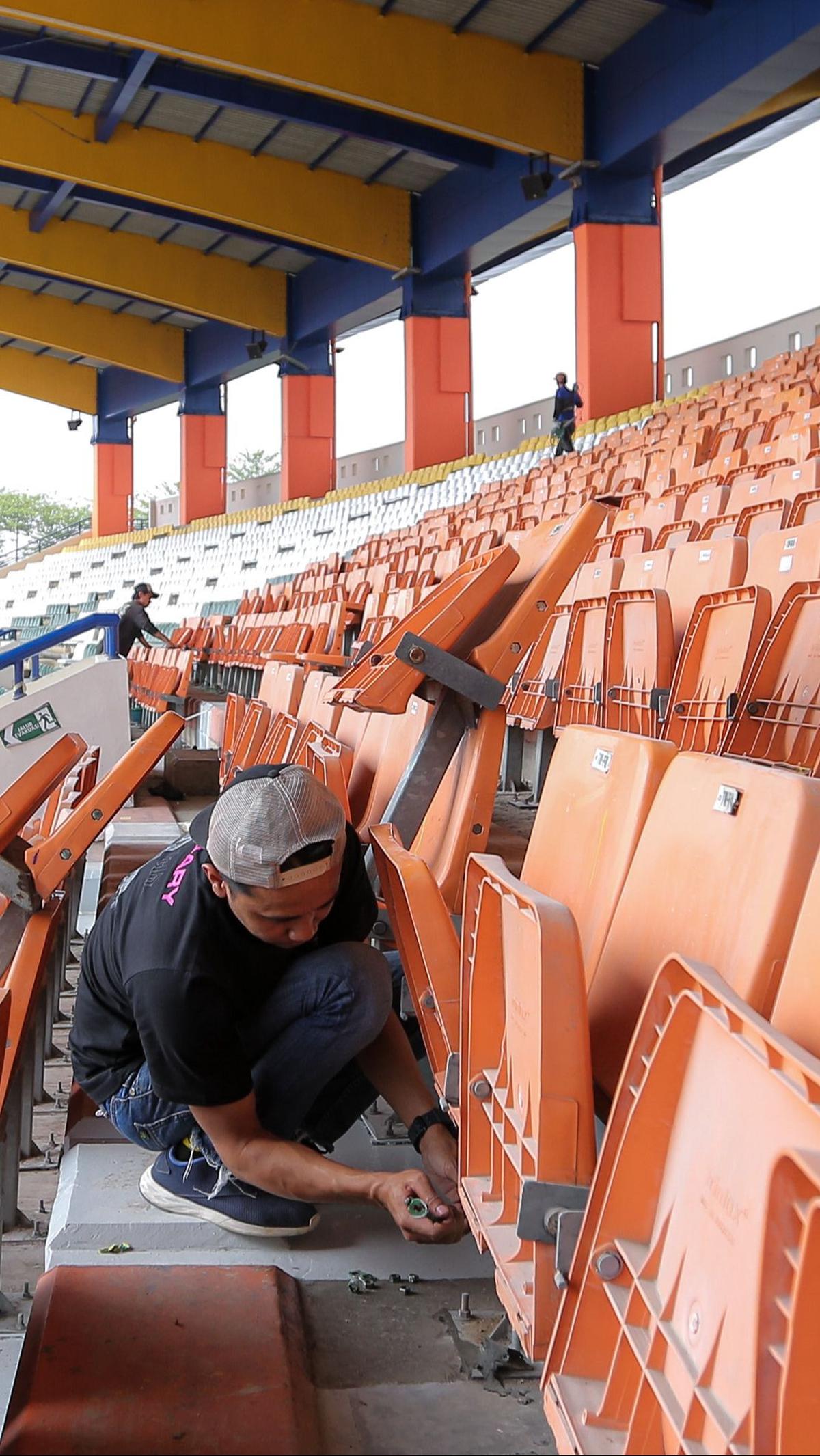 Pekerja melaukan pemasangan kursi penonton pada tribun Stadion&nbsp;Si Jalak Harupat.
