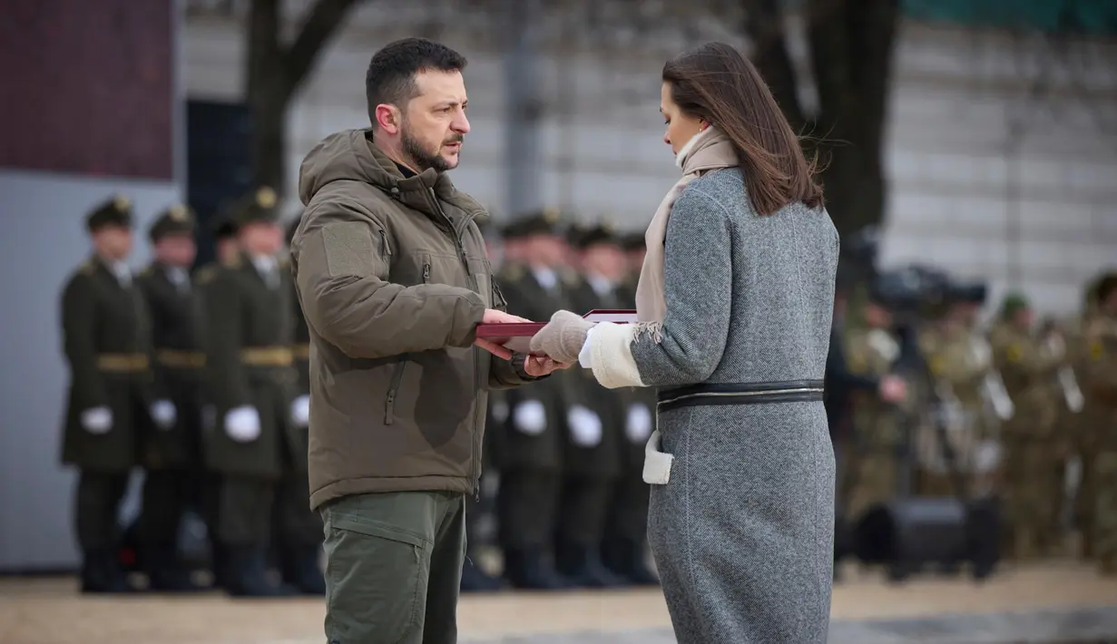 Presiden Ukraina Volodymyr Zelenskyy (kiri) memberikan penghargaan negara kepada seorang kerabat tentara yang gugur dengan penghargaan Pahlawan Ukraina dalam sebuah acara peringatan satu tahun perang Rusia-Ukraina di Kyiv, Ukraina, Jumat, 24 Februari 2023. Dalam pidatonya, Zelenskyy memuji prajurit Ukraina sebagai orang terpenting. Ia mengucapkan terima kasih kepada jutaan warga Ukraina yang berjuang mempertahankan kedaulatan Ukraina. (Kantor Pers Kepresidenan Ukraina via AP)