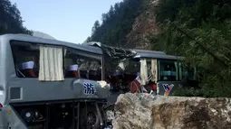 Bus wisata yang rusak saat terjadi gempa terlihat di Jiuzhaigou di provinsi Sichuan barat daya China(9/8). Sedikitnya 12 orang tewas ketika sebuah gempa berkekuatan 6,5 skala Richter melanda China barat day. (AFP Photo/Str/China Out) 
