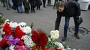Seorang pria menaruh bunga di luar Kedutaan Besar Prancis di Moskow (4/11/2015). Serangan teroris yang terjadi di Paris telah menewaskan sekitar 140 orang. (AFP PHOTO/DMITRY SEREBRYAKOV)