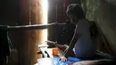 Seorang pria yang menderita penyakit mental duduk dirantai di tempat tidur kamarnya di dalam rumah keluarganya di Curug Sulanjana Desa penginapan Serang, Provinsi Banten, Indonesia (23/3). (REUTERS/Beawiharta)