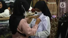 Calon pembeli mencoba seragam sekolah kepada anaknya di Pasar Kebayoran Lama, Jakarta, Jumat (8/7/2022). Menjelang dimulainya tahun ajaran baru, para orang tua disibukkan berbelanja baju seragam dan perlengkapan sekolah untuk anak mereka. (Liputan6.com/Angga Yuniar)