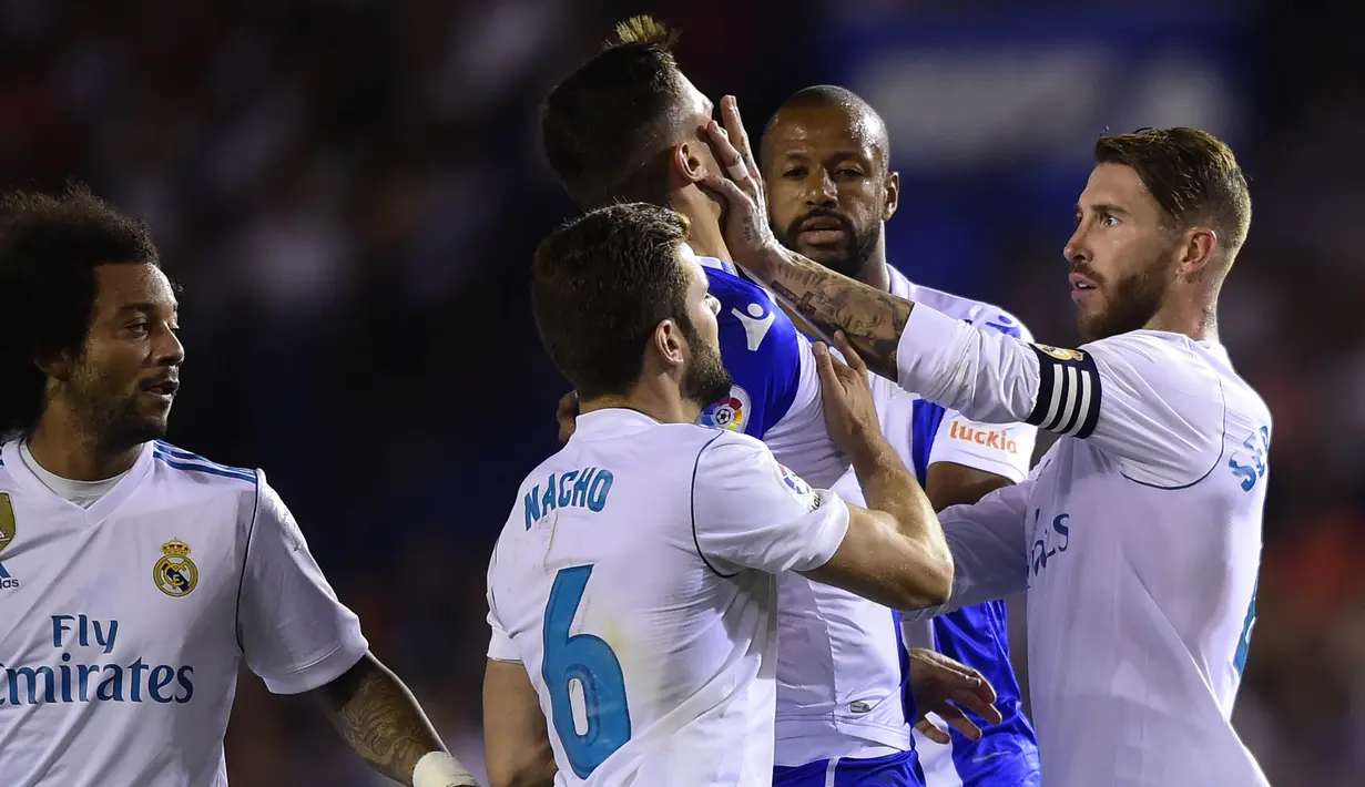 Kapten Real Madrid, Sergio Ramos, mendorong bek Deportivo La Coruna, Fabian Schar, pada laga La Liga di Stadion Riazor, Senin (21/8/2017). Real Madrid menang 3-0 atas Deportivo La Coruna. (AFP/Miguel Riopa)