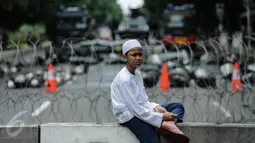 Peserta aksi duduk disekitar kawat berduri saat aksi bela islam 313 di Jalan Merdeka Barat, Jakarta, Jumat (31/3). Mereka menuntut kepada Presiden Jokowi agar melaksanakan undang-undang dengan mencopot gubernur terdakwa, Ahok. (Liputan6.com/Faizal Fanani)