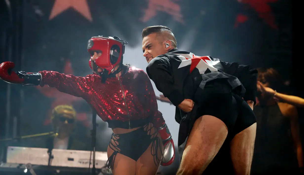 Robbie Williams tampil selama Festival Musik Corona Capital di Meksiko (17/11). Di atas panggung penyanyi Inggris ini kembali menunjukkan celana dalamnya bergambar harimau yang pernah digunakannya di video Rock DJ tahun 2000. (AP Photo/Eduardo Verdugo)
