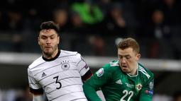 Gelandang Timnas Jerman, Jonas Hector berebut bola dengan pemain Timnas Irlandia Utara, Shayne Lavery pada laga Grup C Kualifikasi Piala Eropa 2020 di Commerzbank Arena, Selasa (19/11/2019). Timnas Jerman sanggup membenamkan Irlandia Utara dengan skor telak 6-1. (AP/Michael Probst)