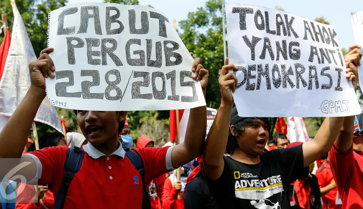 Pengunjuk rasa membawa poster saat melakukan aksi menolak Pergub 228 tahun 2015, Jakarta, Senin (9/11/2015). Massa menilai Pergub tersebut melawan demokrasi dan melanggar HAM. (Liputan6.com/Yoppy Renato)