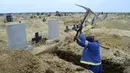 Seorang penggali makam menyiapkan kuburan baru di Pemakaman Motherwell di Port Elizabeth, Afrika Selatan pada 4 Desember 2020. Menteri Kesehatan Afrika Selatan, Zweli Mkhize pada Rabu (9/12/2020) mengumumkan negara itu sekarang sedang mengalami gelombang kedua Covid-19. (AP Photo/Theo Jeftha)