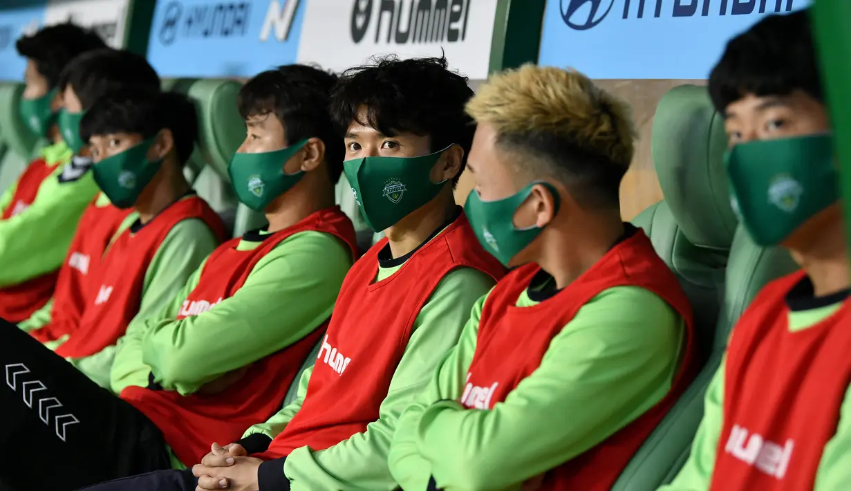 Para pemain Jeonbuk Hyundai Motors menggunakan masker saat melawan Suwon Samsung Blue Wings pada laga K-League di Stadion Jeonju, Korea Selatan, Jumat (8/5/2020). Kembali bergulir di tengah wabah corona, K-League tanpa penonton. (AFP/Jung Yeon-Je)
